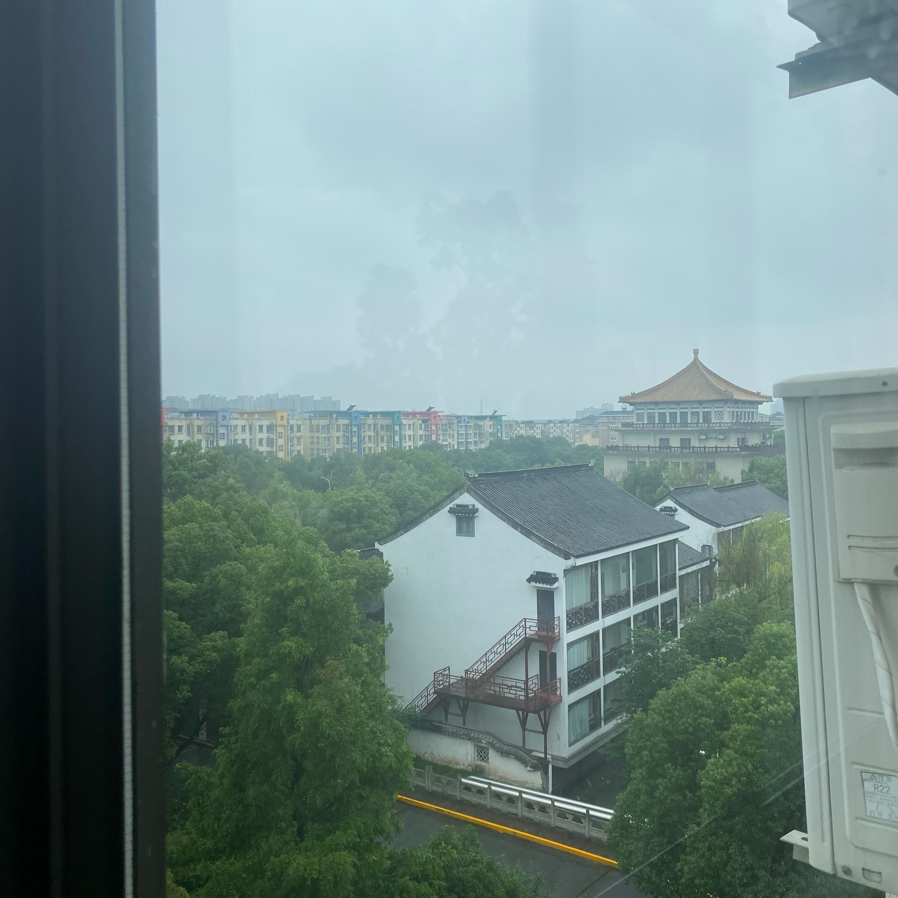 A window with a view of an overcast sky and temple in an East Asian style.