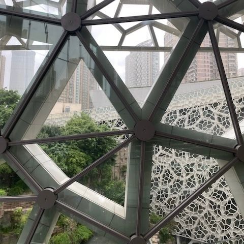 A window with a network-like frame with large nodes and links. There is a view of a silver lattice structure.