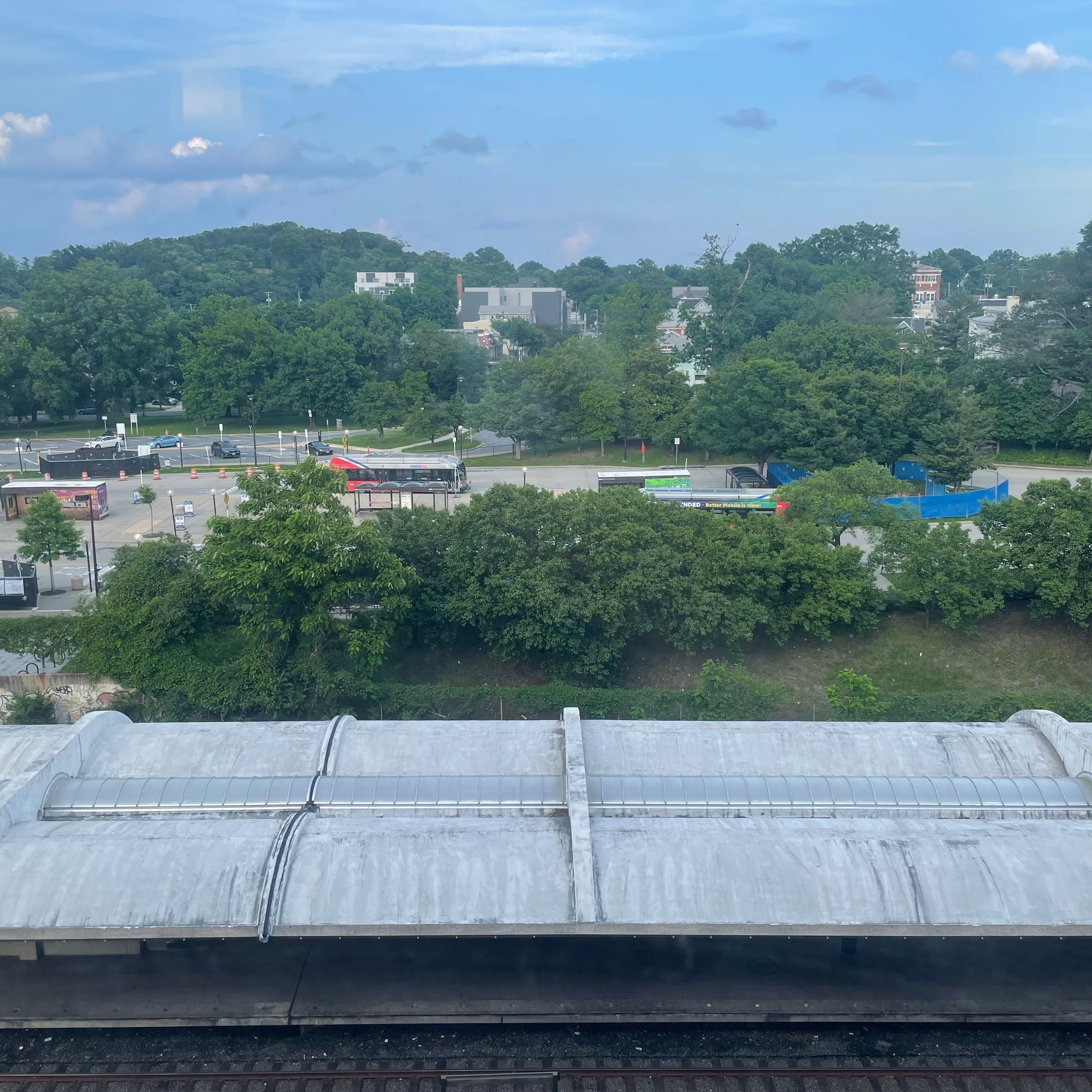 A window with a view of the top of the Brookland-CUA Metro station and the nearby bus station.