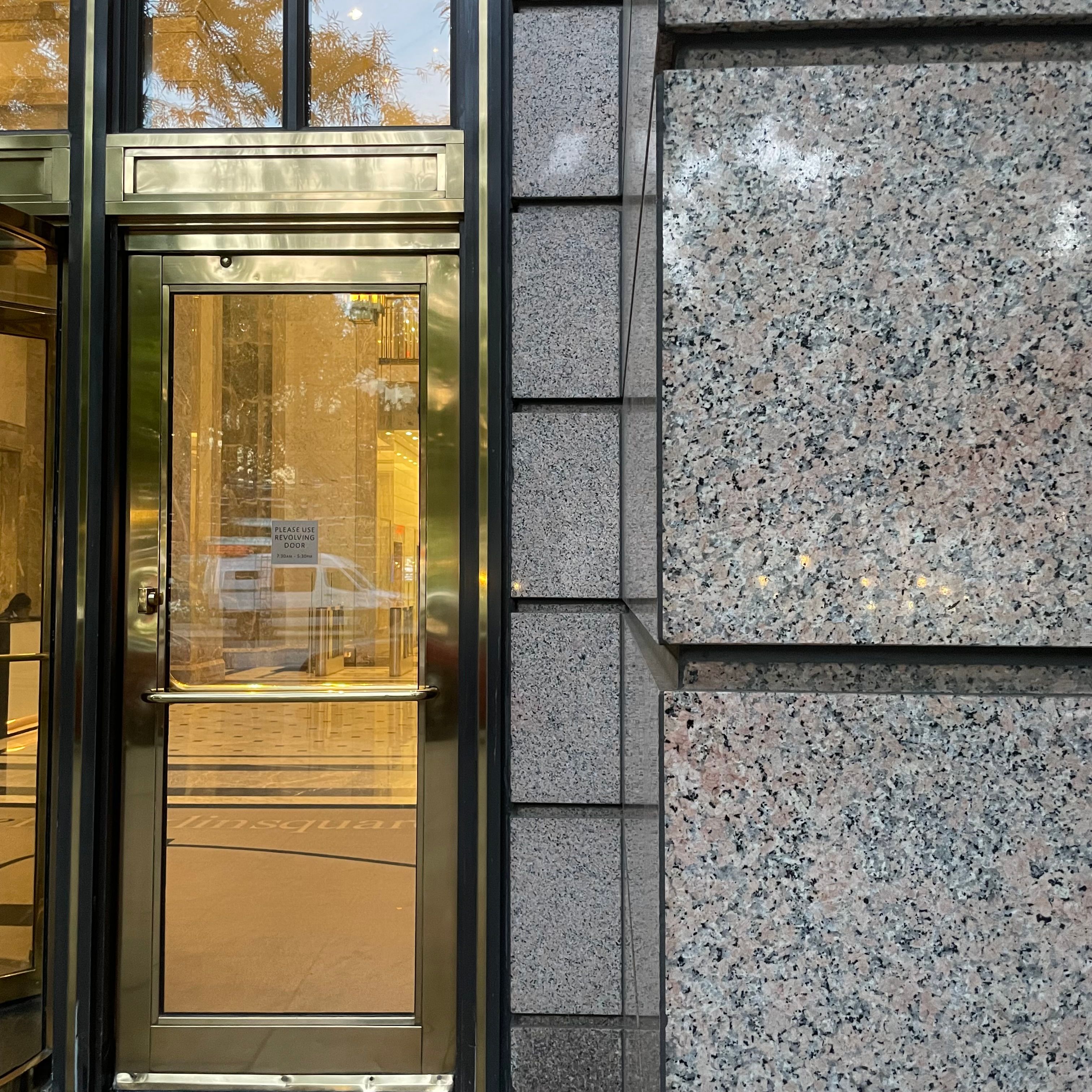 A glass door next to a granite wall.