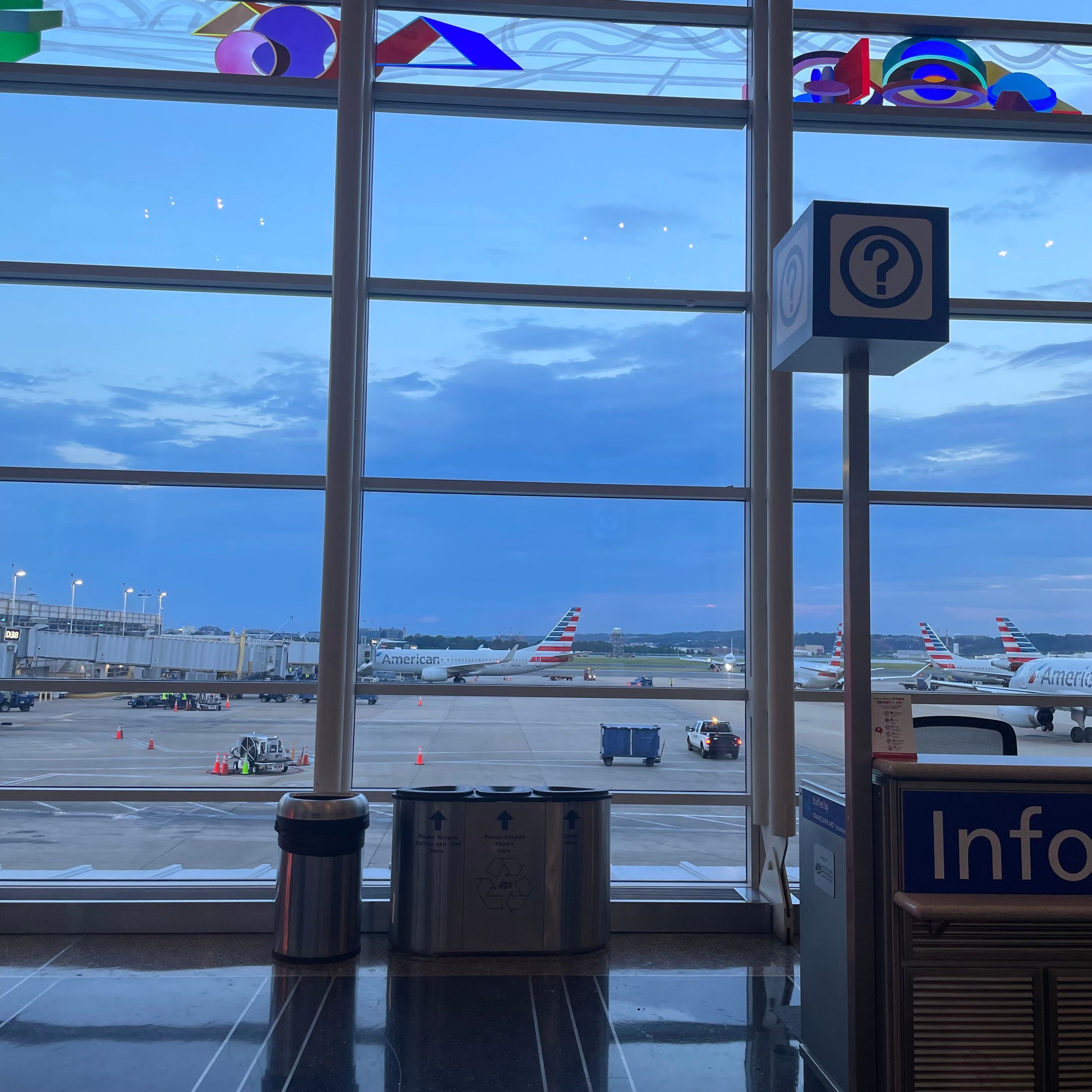 Grid windows with stained glass on top. There is a view of several airplanes.