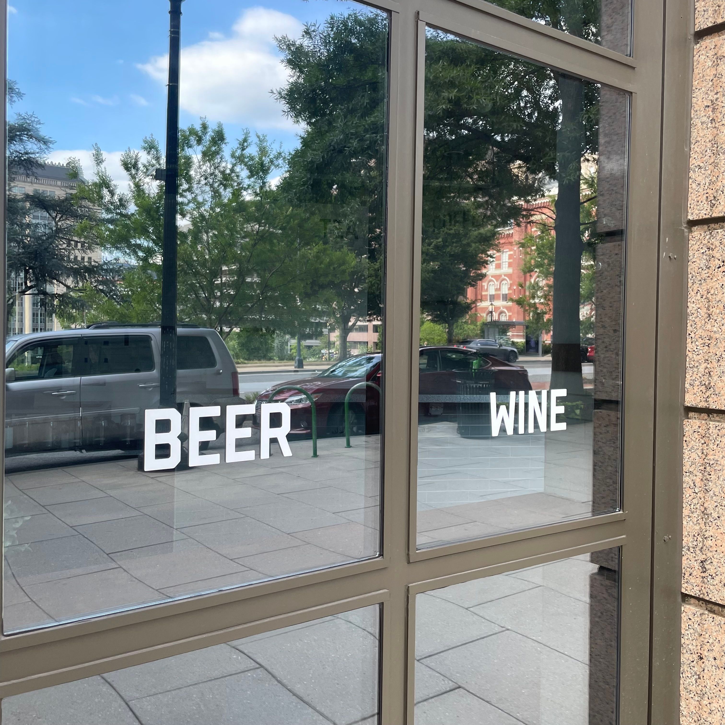 A window with the words 'beer' and 'wine' written on it in white capital letters.